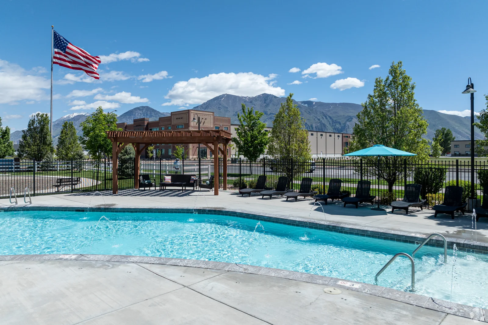 Outlook pool, pergola and turquoise umbrellas with the mountains beyond