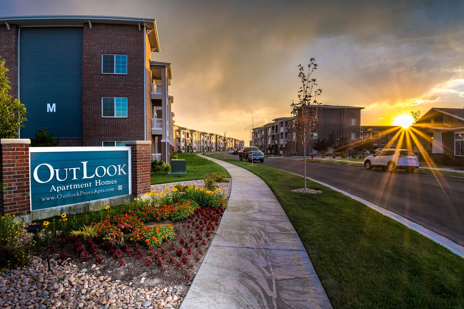 Outlook Apartment Homes entrance and landscaped streetscape at sunset